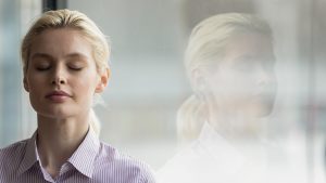 Close up mindful young businesswoman breathing fresh air